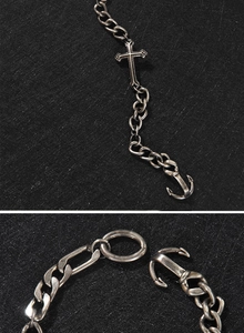 Detail of vintage silver cross pendant and anchor clasp on heavy metal curb chain