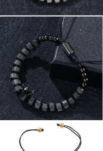 Dettaglio macro del bracciale da uomo con perline nero opaco e ciondolo a corona nera