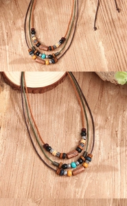 Detail of bohemian layered necklace with multi-color wood beads and woven wax cord