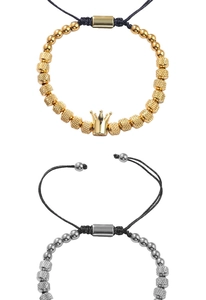 Dettaglio di bracciali intrecciati regolabili con corona dorata e perle in metallo testurizzato