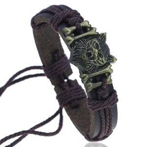 Bracelet vintage en cuir tressé marron avec tête de loup en bronze et os croisés