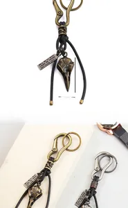 Macro detail of bird skull pendant on leather keychain with vintage metal engraving