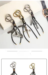 Gros plan de porte-clés vintage en cuir avec breloques sirène et épée rétro