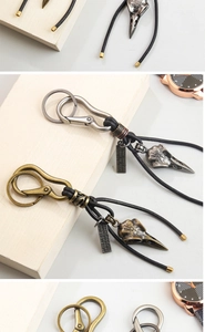 Detail of vintage punk bird skull keychains with leather cord and engraved metal tag