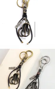 Close-up of vintage cobra pendant and woven leather strap with engraved metal tag