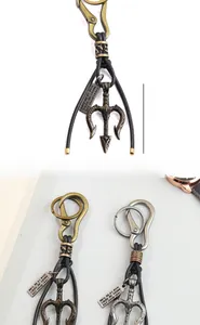 Detail view of vintage trident keychains with a rectangular engraved tag and size guide