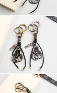 Detail of retro cobra pendant keychains in antique bronze and silver metal finishes