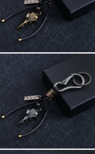Detail of vintage crow skull keychain with viking compass engraving and black leather tassel