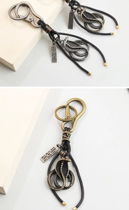 Detailed view of vintage cobra metal keychains with braided leather cord and engraved tags
