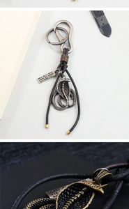 Macro shot of cobra snake metal pendant with leather strap and engraved tag detailing