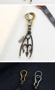 Close-up of vintage bronze trident pendant with braided leather cord and engraved tag