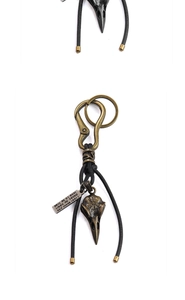 Macro detail of retro leather keychain with bird skull pendant and bronze hardware