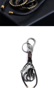 Detailed close-up of retro cobra keychain showing snake scales and woven leather cord