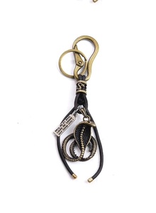 Macro detail of retro metal cobra pendant with engraved quote tag on a keychain