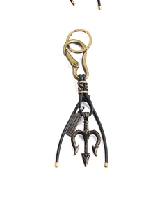 Macro detail of bronze trident pendant with leather strap and engraved metal plaque