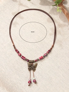 Detailed close-up of 89cm vintage ceramic butterfly pendant with brown woven cord