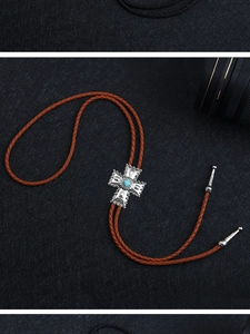Gros plan sur un bolo tie western avec pendentif croix argentée et turquoise bleue