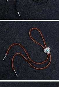 Detail of silver heart-shaped bolo tie buckle with blue turquoise and woven leather cord