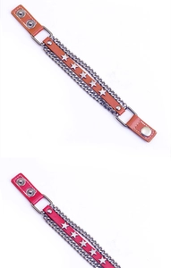 Dettaglio del bracciale punk in pelle con borchie a stella e catena multistrato