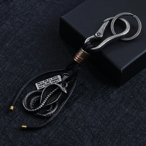 Vintage metal cobra keychain with leather cord and engraved motivational pendant