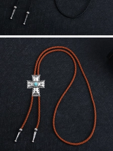 Vue détaillée du pendentif bolo tie en forme de croix argentée avec pierre turquoise bleue