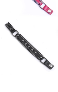 Dettaglio di bracciale punk in pelle con stelle di metallo e catene stile vintage