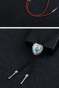 Detail of heart-shaped turquoise bolo tie with braided leather cord and silver tips