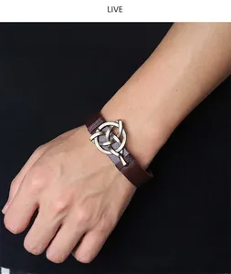 Detail eines Retro-Lederarmbands mit keltischem Knoten aus Bronze am Handgelenk getragen