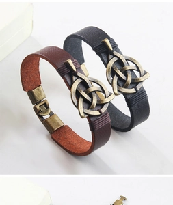 Detailaufnahme von keltischen Triquetra-Knoten auf braunen und schwarzen Lederarmbändern