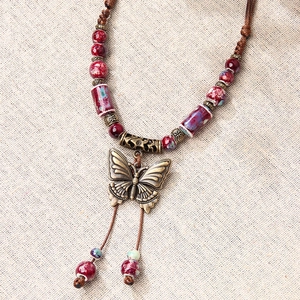 Retro butterfly ceramic pendant necklace with brown woven cord and ethnic metal beads