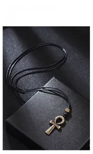 Macro shot of bronze Ankh pendant with ancient Egyptian patterns on black jewelry box