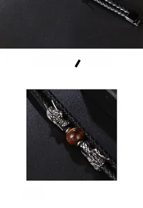 Close-up of double-layer braided leather bracelet with silver dragon heads and tiger eye stone
