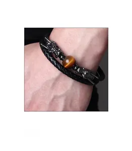 Detail of double-layer braided leather bracelet with tiger eye stone and dragon heads