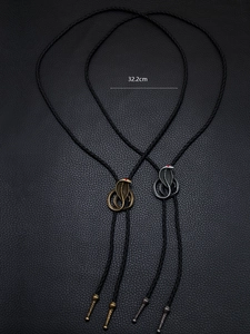 Detail of cobra bolo tie with red rhinestone eyes in bronze and silver finish