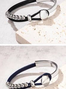 Dettaglio di un bracciale in pelle intrecciata a doppio strato con perle metalliche e chiusura magnetica