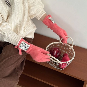 Coral pink knitted gloves with bow ribbon and brand label for autumn winter warmth