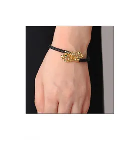 Gros plan du bracelet en cuir tressé noir avec fermoir tête de serpent dorée et yeux verts