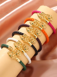 Détail de bracelets serpent tissés avec têtes en filigrane doré et yeux en pierre verte