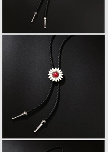 Détail d'une cravate bolo marguerite avec pétales blancs et perle rouge sur cordon