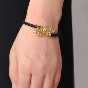Bracelet serpent tressé doré avec yeux verts et écailles ajourées pour femme