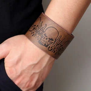 Brown wide leather bracelet for men featuring embossed skull and flame punk patterns