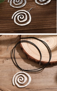 Detail von böhmischer Spirale Anhänger Halskette und Ohrringen auf rustikalem Holz