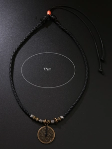 Détail du pendentif en pièce de cuivre rétro avec gravures et cordon noir de 77cm