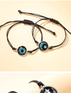 Detalle de pulseras para parejas tejidas a mano con dijes luminosos de sol y luna en vidrio