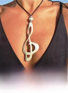 Detail view of a vintage silver music note G-clef pendant on a black cord necklace