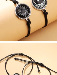 Detalle de pulseras ajustables tejidas para parejas con colgantes de sol y luna