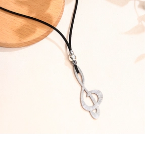 Detail of music note pendant necklace with vintage silver texture on black cord necklace