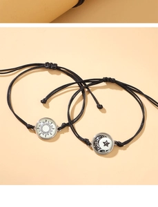 Detalle de pulseras de pareja de sol y luna tejidas a mano con cordones negros ajustables