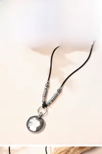 Détail du pendentif disque en alliage argenté avec perles rétro et tubes ciselés