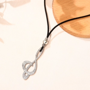 Retro musical note pendant necklace with silver treble clef and black cord on white surface